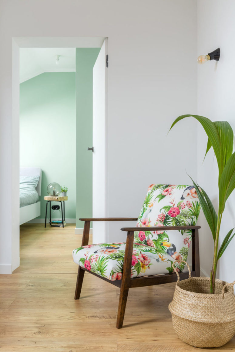A bright floral chair cheers up the living room and helps it transition into the bedroom
