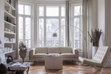 09 a contemporary Parisian living room with all-whites and a hardwood parquet floor to soften the space