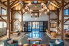 11 a beautiful barndominium space with wooden beams, exposed pipes and a statement chandelier plus muted touches of color