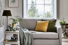11 a neutral grey loveseat with colorful pillows and a printed blanket is an ideal piece for your cozy reading nook