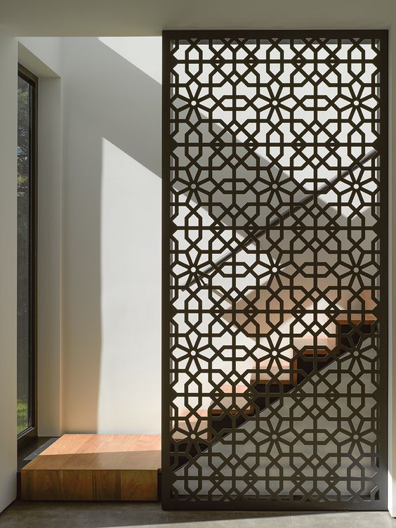 a sheer laser cut screen of Douglas fir is a stylish way to divide spaces and accent them a bit