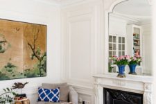 11 white walls with molding and warm-colored hardwood parquet floors create a chic combo for a Parisian living room