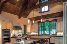 12 a barndominium kitchen and dining space with a ceiling with wooden beams and suspended lamps