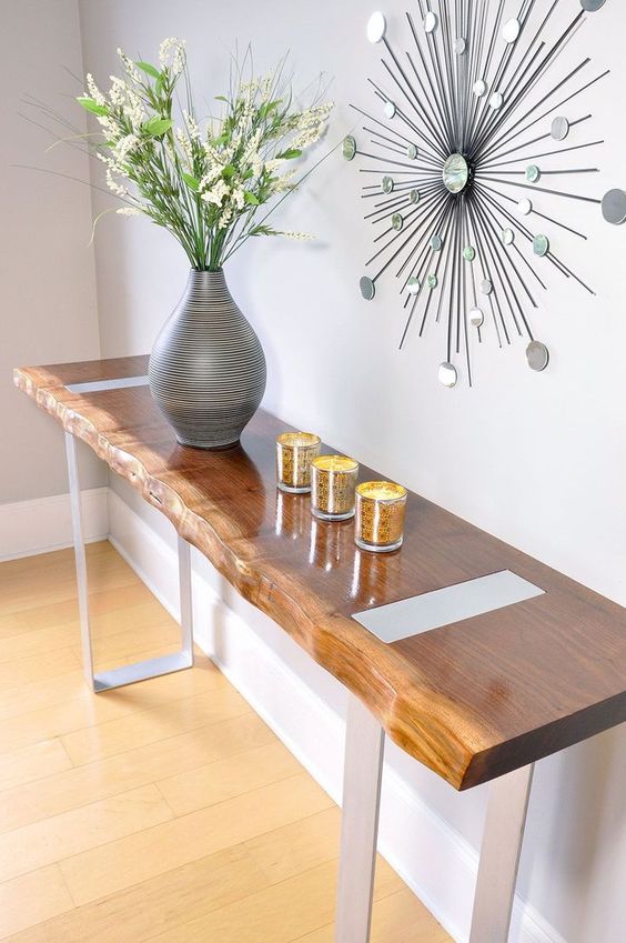 A sleek entryway console with a live edge and contrasting metal legs for a chic and one of a kind look