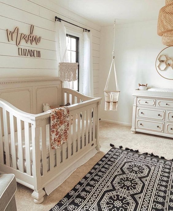 a traditional rustic nursery with boho elements like rugs, textiles and a wicker lampshade