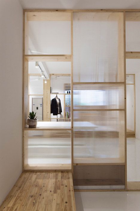 a wood and frosted glass room divider with plenty of storage doesn't look bulky and provides storage