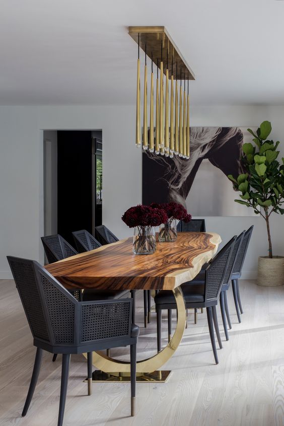 a super elegant and modern dining space with black geometric chairs, a live edge dining table and gilded touches