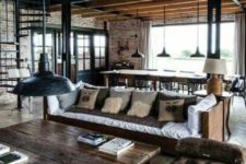 17 a moody industrial barndominium space with brick walls, dark stained wooden furniture and rough metal touches