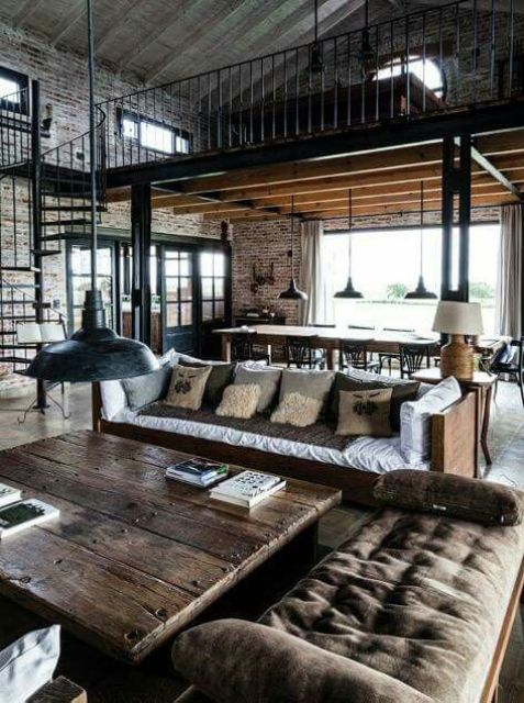 a moody industrial barndominium space with brick walls, dark stained wooden furniture and rough metal touches