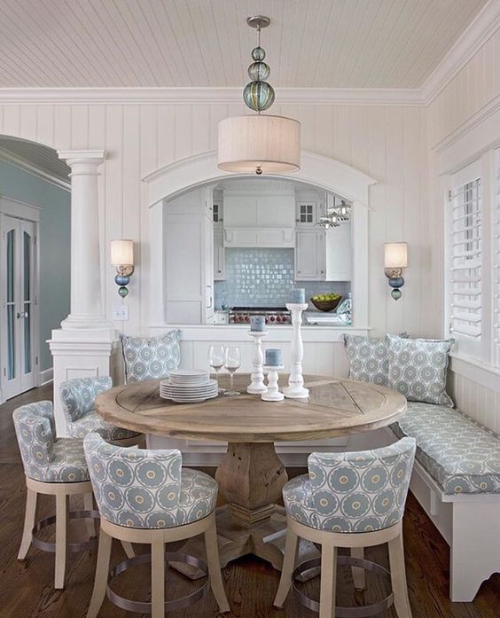 a rustic round table and patterned chairs and a bench for a cozy rustic dining space with a beachy feel