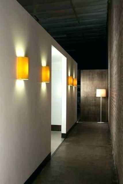 minimalist yellow wall sconces add color to the space and make the hallway lit up enough, though not too much