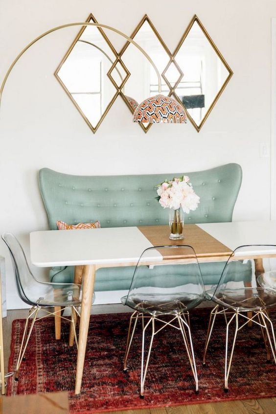 a catchy dining space with an aqua bench, clear acrylic chairs and a color block table