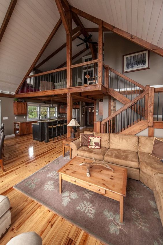 a cool rustic barndominium with much stained wood, light brown leather and traditional furniture