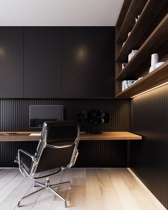 a minimalist black home office with a floating wooden desk and a shelving unit of rich stained wood
