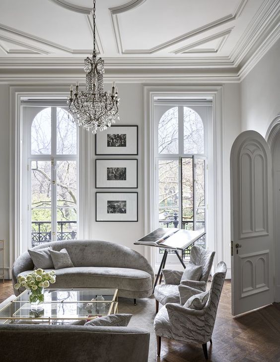 a white Parisian living room with a chic and sophisticated crystal chandelier that adds to the style
