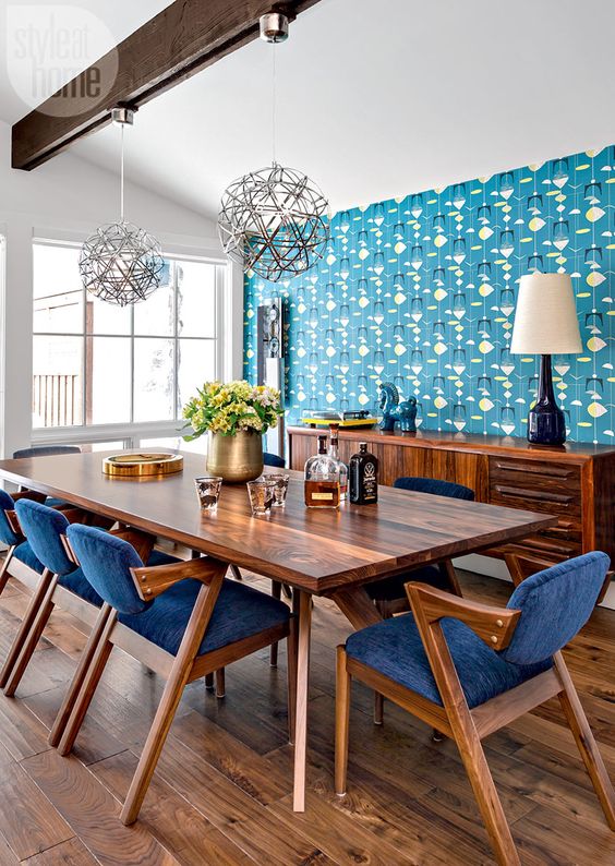 a rich stained wooden dining table and matching rich wood and bright blue dining chairs that look bold