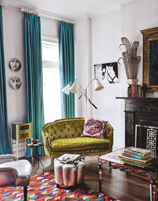 an eclectic living room with colorful touches and a pistachio green loveseat with tufted upholstery that adds chic