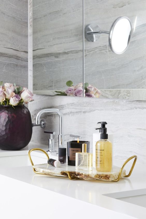 a chic and glam bathroom tray of agate and gold handles plus luxurious bath products