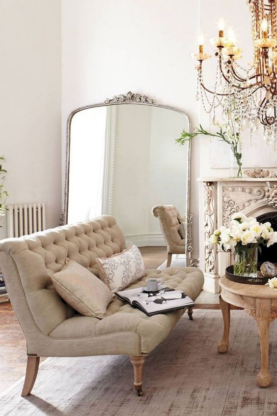 a super ornate fireplace and a crystal chandelier make this neutral space truly Parisian and tres chic