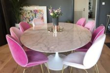 26 a glam dining space with a round marble dining table and white and pink velvet chairs