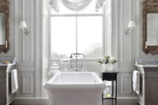 a beautiful vintage-inspired bathroom with a white tub, curtain, mirrors and chic vanities plus a rug