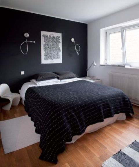 a contemporary bedroom with a black accent wall, a white bed and mismatching nightstands and lamps