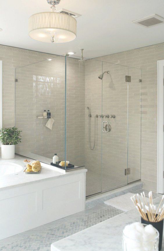 light beige tiles in the shower space and a pendant lamp add warmth and coziness to the neutral transitional bathroom