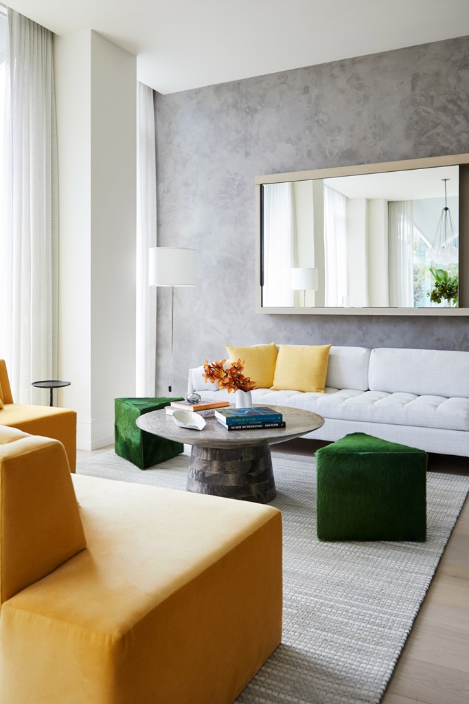 The living room is done with yellow and green touches and geometric shapes plus a statement mirror