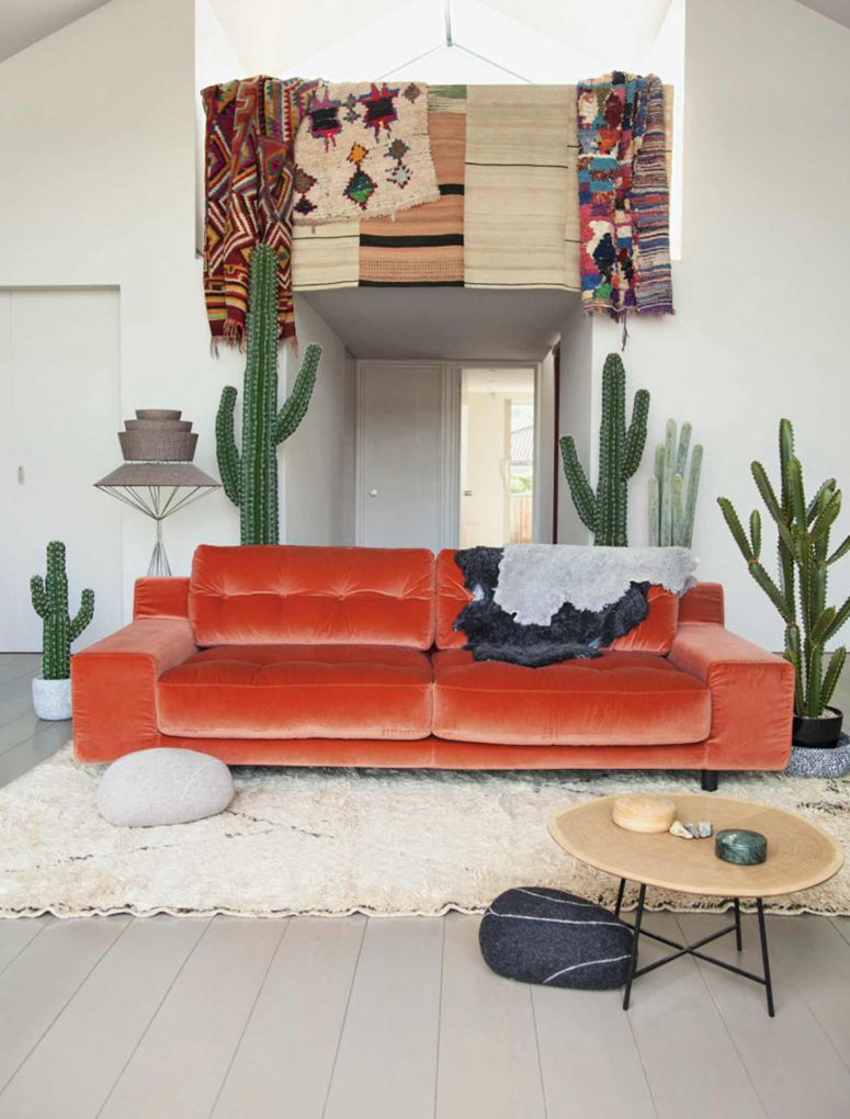 a chic orange velvet sofa makes a bold statement in the boho desert living room and becomes a centerpiece