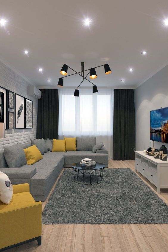 a stylish contemporary living room done with ceiling lights and a statement black chandelier wiht a mid-century modern feel