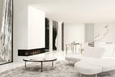 04 The living room is done with white marble, sleek white panels and stylish and simple furniture