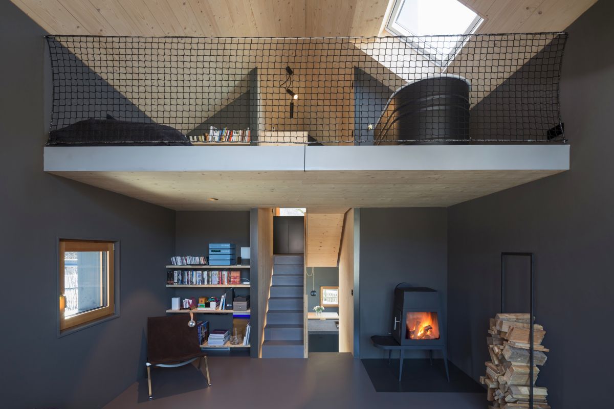 There's a living room zone with a reading nook, a hearth and a stand with firewood