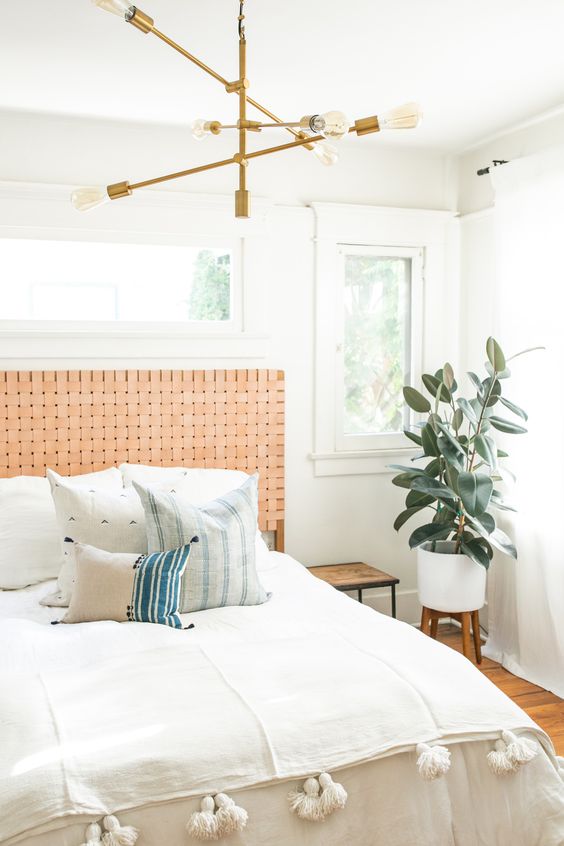 a muted orange woven leather headboard is a stylish accent for this boho bedroom that adds a warm feel to it