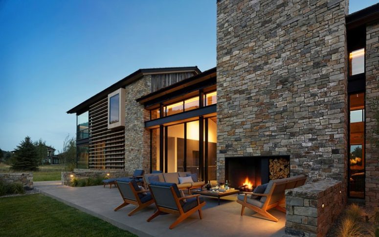 There's an outdoor living room with a fireplace, mid-century modern furniture and lights