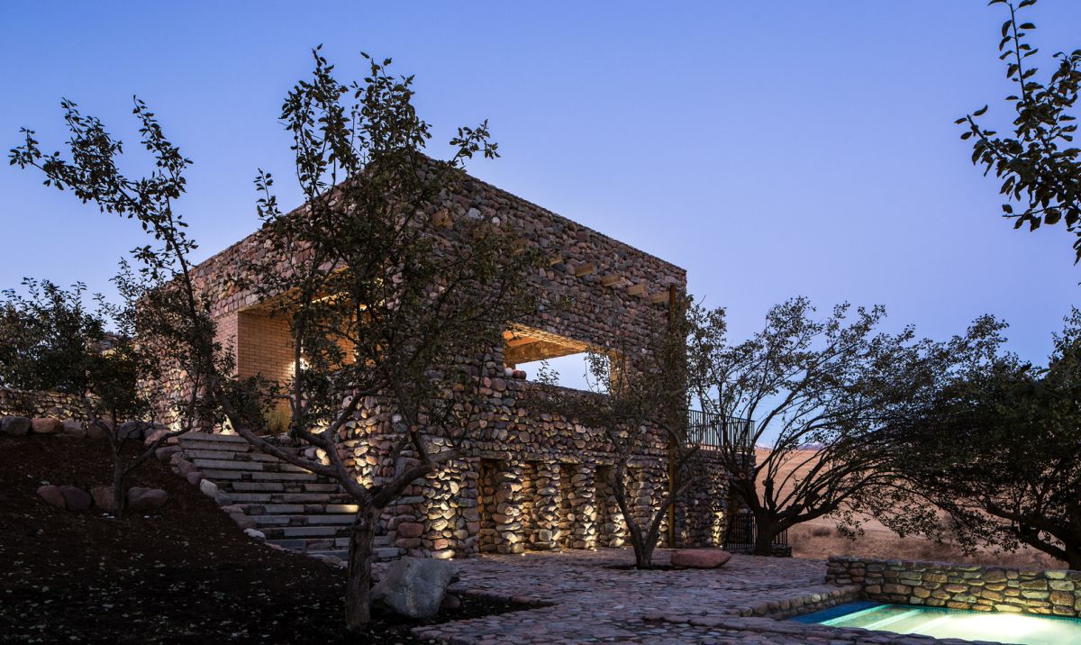 There's an outdoor space with trees, stones and a built-in swimming pool with inner lights