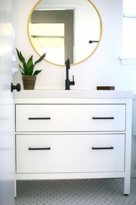 an Ikea Hemnes 2-drawer sink cabinet hacked with elegant black handles and a white countertop