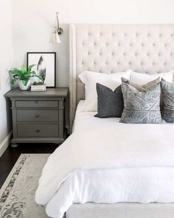 a creamy upholstered bed and a statement tall wingback headboard is a chic yet neutral enough idea for a farmhouse bedroom