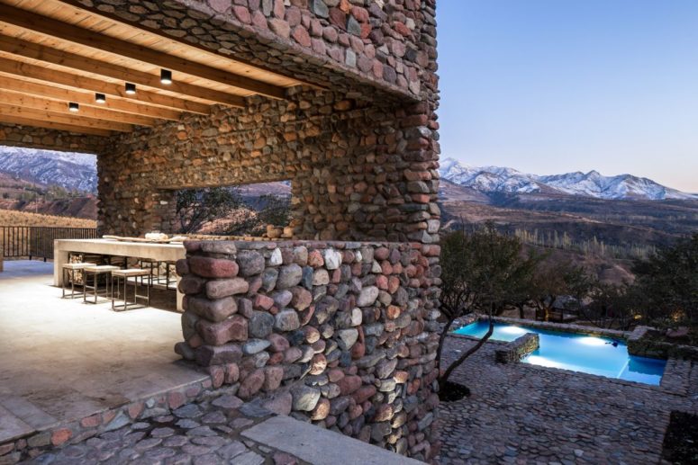 You may also see an outdoor dining space with concrete furniture and a view to the mountains