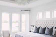07 a creamy tufted headboard and a crystal chandelier are glam and cool accents for the space