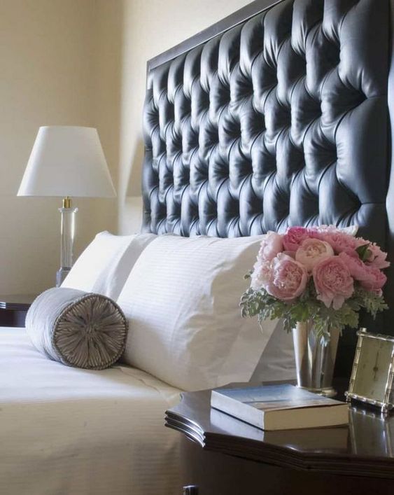 a super tall black tufted headboard with framing is a bold and dark statement in the neutral bedroom