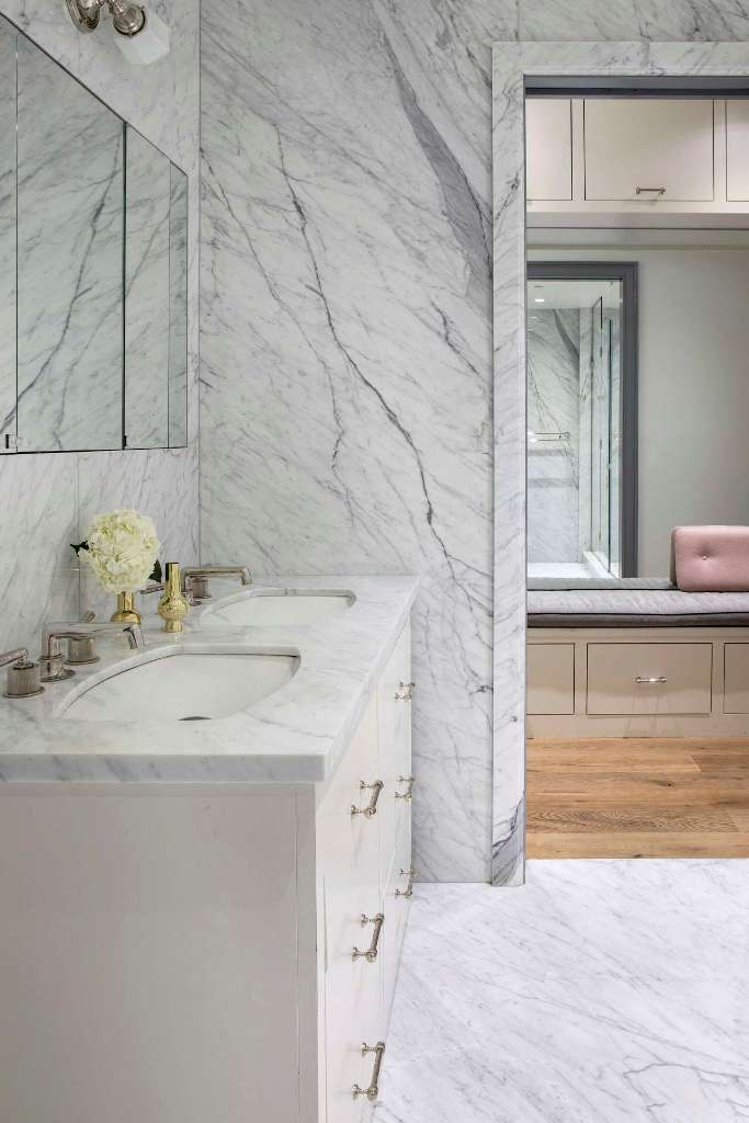 The bathroom is done with white marble, which adds a refined touch at once