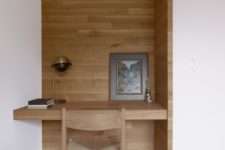08 The home office nook is clad with wood, too, and there’s a built-in desk and a woven chair plus a brass lamp