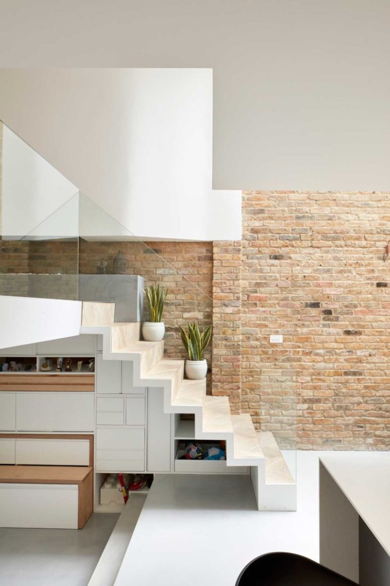 The staircase is ultra-minimalist and very sleek, with hidden storage and glass railing