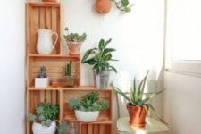 08 a wooden crate shelving unit acts as a garden with potted greenery, a great idea for decorating a small balcony