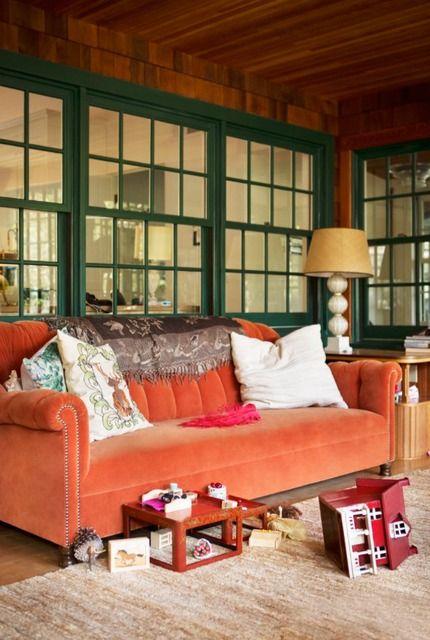 an orange velvet sofa brings traditional fall chic to this screened porch and makes it feel like fall