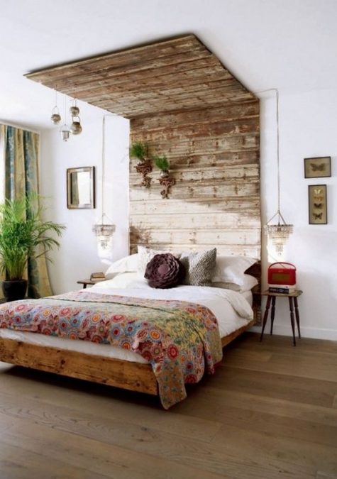 a weathered and aged wood headboard that is extended to the ceiling to have a bigger impact