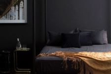 10 an elegant and moody bedroom with black walls, a framed bed and a statement artwork looks very relaxing