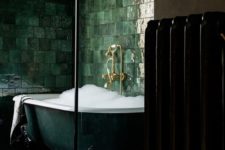 10 an exquisite dark green clawfoot bathtub surrounded with glossy green tiles on the walls