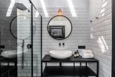 11 The bathroom is done with white subway tiles and black elements for a bold contrasting look