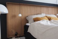 11 a sleek wooden headboard on a black wall makes a cozy and soothing statement and adds a calmign feeling to the room